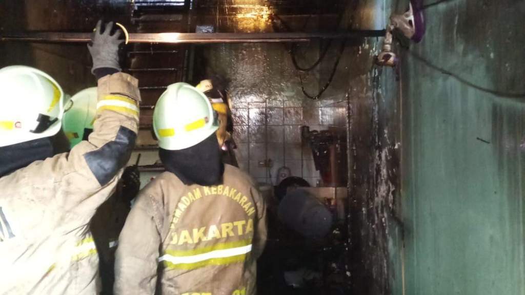 Petugas pemadam kebakaran melakukan pendinginan di rumah kontrakan yang terbakar di Sunter Agung