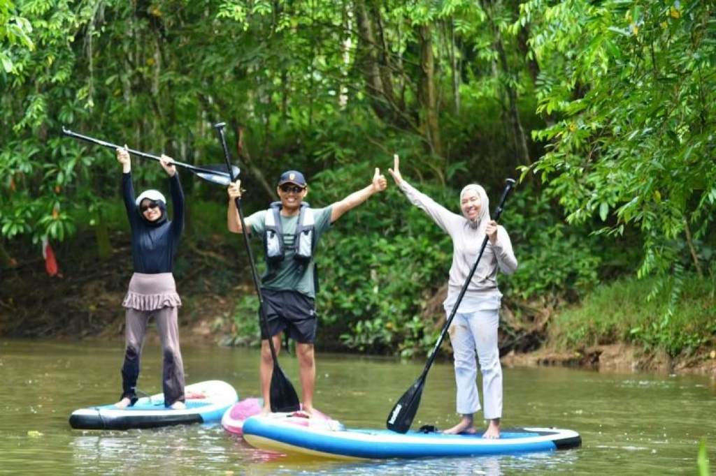 Aksi pejabat Kemenham Kaltim dan komunitas memungut sampah menggunakan paddle board di Samarinda
