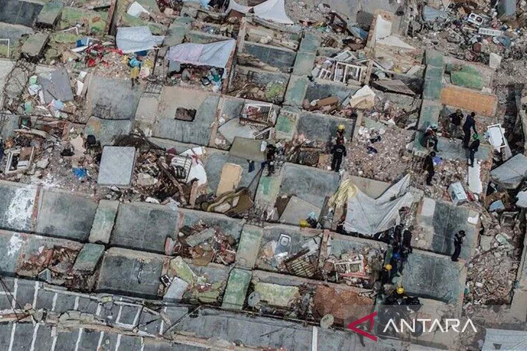 Petugas penyelamat mencari korban di balik puing-puing bangunan runtuh pasca gempa Venezuela