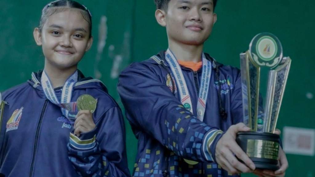 Suthan Akram Maulana dan Mutiara Asy Syifa memegang piala juara bulu tangkis O2SN Jawa Barat