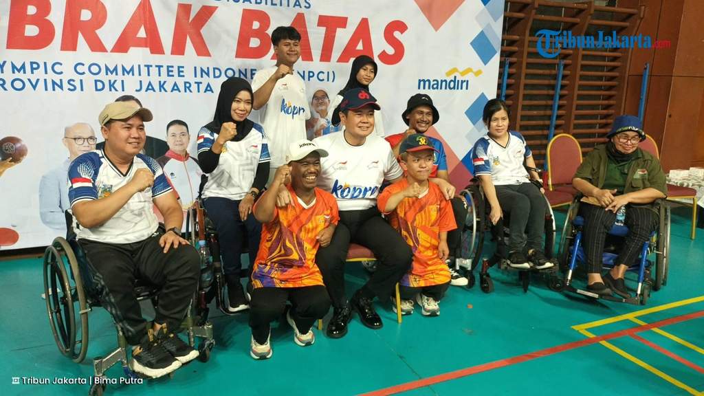 Warga Jakarta berkumpul menyaksikan pertandingan sepak bola melalui layar raksasa di dalam GOR