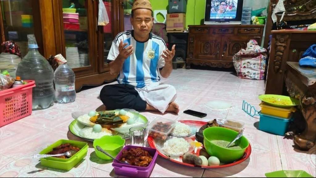 Alimuddin Budung melakukan ritual mabbaca dengan hidangan makanan tradisional Bugis Makassar