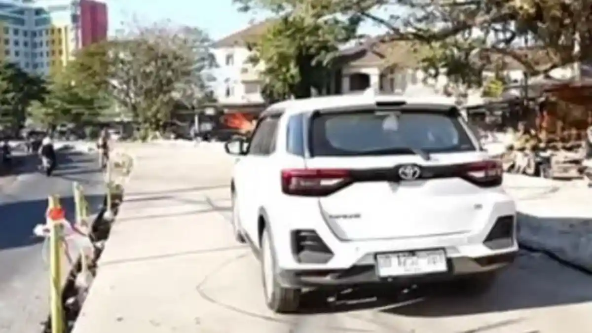 Mobil Toyota Raize putih melintasi Jalan Beton Aroepala Makassar yang baru diresmikan